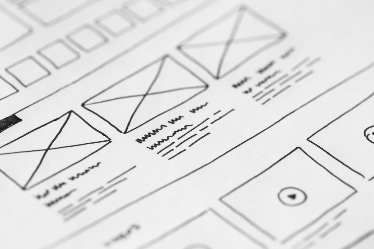 Gros plan détaillé d’une maquette filaire dessinée à la main sur papier pour un projet UX.